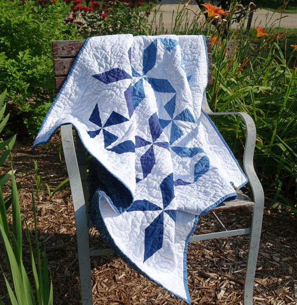 Quilting for All Displayed by a Quilt Featuring an Assembled Border and Ombre Pinwheel Blocks